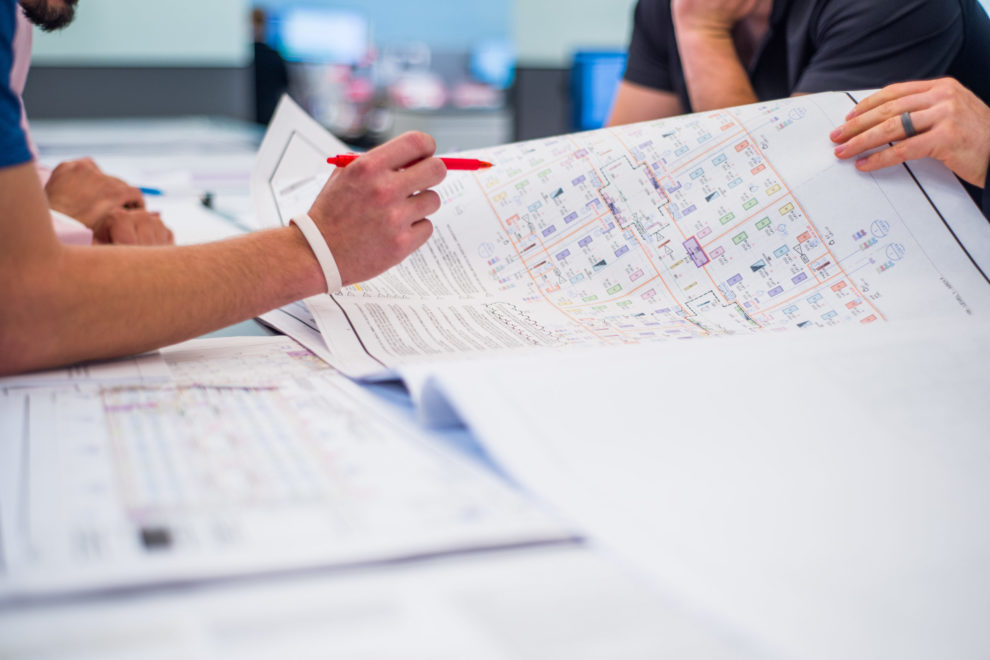 Three Sea-Tac Lighting team members look over controls diagrams