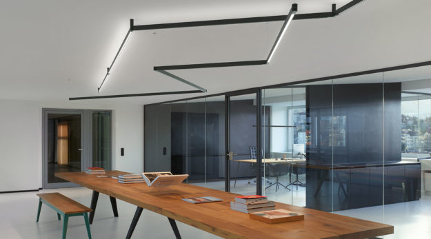 Architectural linear lighting in a zig-zag configuration over an office meeting table